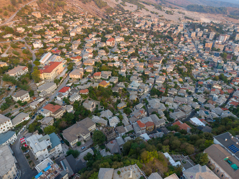 Aerial view of the historic city of Gjirokaster featuring traditional stone houses with slate roofs and narrow streets in Gjirokaster Gjirokaster County Albania. Aerial view of the historic city of Gjirokaster featuring traditional stone houses with slate roofs and narrow streets in Gjirokaster Gjirokaster County Albania.