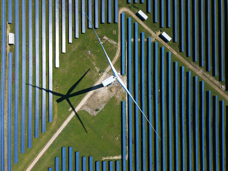 Aerial view of Chelveston Wind Farm with a wind turbine and solar panels on a green field in Wellingborough England United Kingdom. Aerial view of Chelveston Wind Farm with a wind turbine and solar panels on a green field in Wellingborough England United Kingdom.