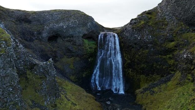 Aerial view of Bugsfoss waterfall cascading down cliffs Iceland.