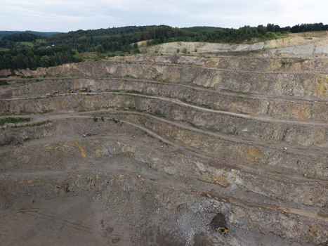 Aerial view of Porphyry Mine Zalas showing terraced rock walls heavy machinery and surrounding forest in Frywald Wojewodztwo Malopolskie Poland.