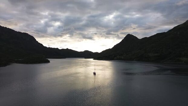 Aerial view of a sailboat on a fjord in Senja Norway.