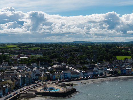 Aerial view of Donaghadee Harbour with colorful waterfront buildings historic stone pier and green landscape under a bright sky in Donaghadee Northern Ireland United Kingdom. Aerial view of Donaghadee Harbour with colorful waterfront buildings historic stone pier and green landscape under a bright sky in Donaghadee Northern Ireland United Kingdom.