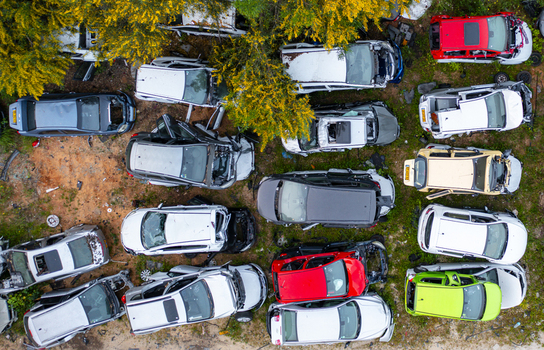 Aerial view of a car junkyard with numerous wrecked vehicles in various colors scattered among trees and dirt in Petah Tikva Center District Israel. Aerial view of a car junkyard with numerous wrecked vehicles in various colors scattered among trees and dirt in Petah Tikva Center District Israel.