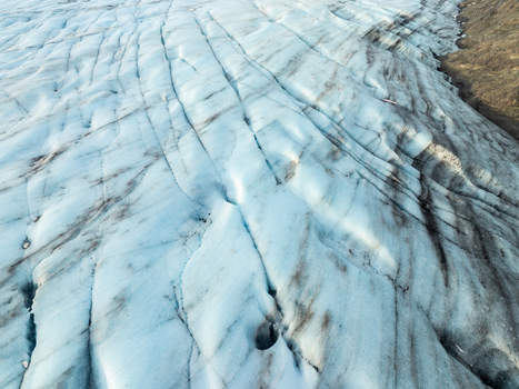 Aerial view of Breidamerkurjokull glacier with deep crevasses and dark volcanic ash streaks in Sveitarfelagid Hornafjordur Iceland. Aerial view of Breidamerkurjokull glacier with deep crevasses and dark volcanic ash streaks in Sveitarfelagid Hornafjordur Iceland.
