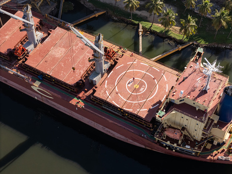 Aerial view of a large cargo ship with a helipad on its deck docked on the Rio Ozama in Santo Domingo Santo Domingo Dominican Republic.