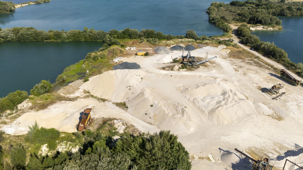Aerial view of the Extraccion de aridos Lima SL quarry with piles of sand gravel industrial machinery and surrounding water bodies in Vilarino das Poldras Ourense Spain. Aerial view of the Extraccion de aridos Lima SL quarry with piles of sand gravel industrial machinery and surrounding water bodies in Vilarino das Poldras Ourense Spain.
