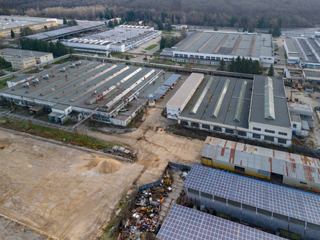 Aerial view of sprawling industrial buildings with varied roof textures and tones nestled near a dense forest Detva Banskobystricky kraj Slovakia. Aerial view of sprawling industrial buildings with varied roof textures and tones nestled near a dense forest Detva Banskobystricky kraj Slovakia.