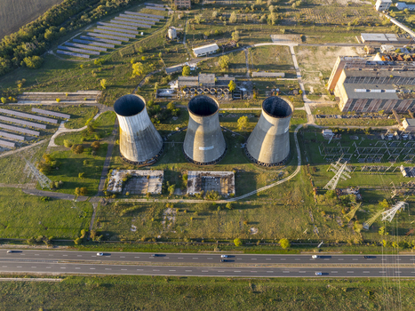 Aerial view of the abandoned Inota Power Plant cooling towers surrounded by industrial ruins power lines and green fields in Varpalota Hungary. Aerial view of the abandoned Inota Power Plant cooling towers surrounded by industrial ruins power lines and green fields in Varpalota Hungary.