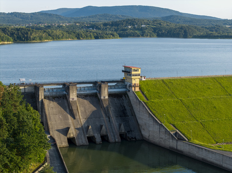 Aerial view of the Dobczyce Dam with its concrete structure control tower and grassy embankment overlooking the reservoir Dobczyce Lesser Poland Poland.