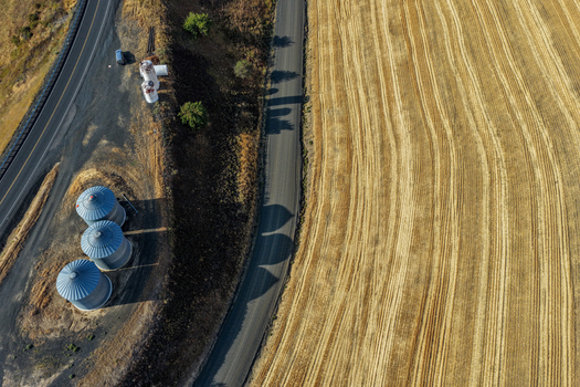 Aerial view of grain silos next to a rural road and harvested wheat fields in the Palouse Washington United States. Aerial view of grain silos next to a rural road and harvested wheat fields in the Palouse Washington United States.