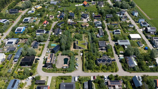 Aerial view of Ecodorp Bolderburen featuring sustainable houses with green roofs solar panels and lush gardens in Almere Flevoland Netherlands. Aerial view of Ecodorp Bolderburen featuring sustainable houses with green roofs solar panels and lush gardens in Almere Flevoland Netherlands.