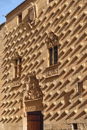 Salamanca Spain 01 December 2025 View of the facade of the Casa de las Conchas with its iconic scallop shells ornate Gothic windows and stone carvings under bright sunlight. Salamanca Spain 01 December 2025 View of the facade of the Casa de las Conchas with its iconic scallop shells ornate Gothic windows and stone carvings under bright sunlight.