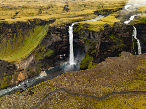 Aerial view of Haifoss waterfall cascading down dramatic mossy cliffs into a deep canyon with a winding river in the volcanic landscape of Skeida og Gnupverjah Iceland. Aerial view of Haifoss waterfall cascading down dramatic mossy cliffs into a deep canyon with a winding river in the volcanic landscape of Skeida og Gnupverjah Iceland.