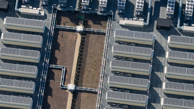 Aerial view of an industrial data center facility featuring rows of cooling units and complex piping systems in Dietzenbach Hessen Germany. Aerial view of an industrial data center facility featuring rows of cooling units and complex piping systems in Dietzenbach Hessen Germany.