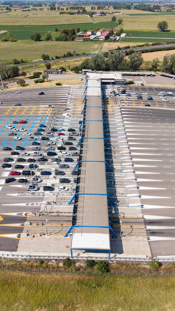 Aerial view of the Autostrada A1 Melegnano toll plaza featuring multiple vehicle access lanes highway infrastructure and traffic in Melegnano Lombardy Italy.