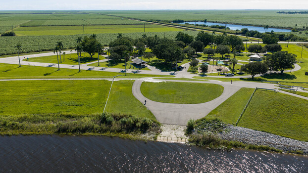 Aerial view of the park and boat ramp at Pahokee Marina surrounded by lush green fields and palm trees in Pahokee Florida United States. Aerial view of the park and boat ramp at Pahokee Marina surrounded by lush green fields and palm trees in Pahokee Florida United States.