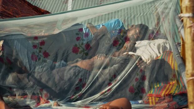 View of men sleeping under a mosquito net at Sadarghat Bangladesh.