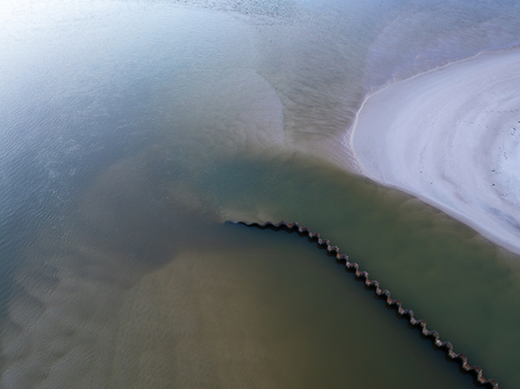 Aerial view of Lagoa de Obidos featuring a zig zagging breakwater and sandy beach with calm turquoise waters in Foz do Arelho Leiria District Portugal. Aerial view of Lagoa de Obidos featuring a zig zagging breakwater and sandy beach with calm turquoise waters in Foz do Arelho Leiria District Portugal.