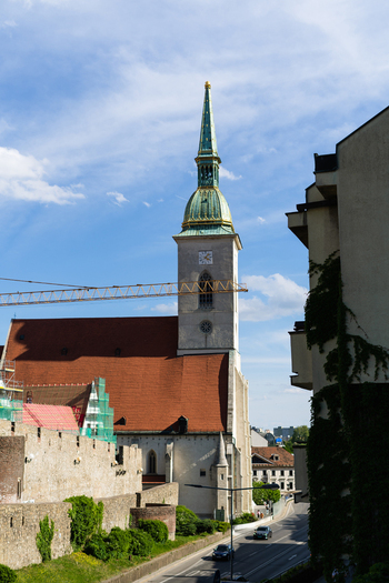 View of St. Martin s Cathedral with its iconic green spire and historic city walls under a blue sky in Bratislava Bratislava Region Slovakia. View of St. Martin s Cathedral with its iconic green spire and historic city walls under a blue sky in Bratislava Bratislava Region Slovakia.