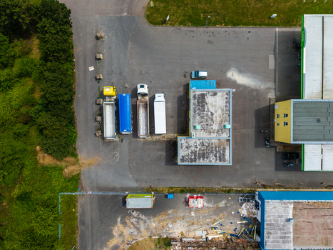 Aerial view of a commercial industrial site with parked trucks a flat roofed building and surrounding greenery in Zebrak Central Bohemian Region Czechia. Aerial view of a commercial industrial site with parked trucks a flat roofed building and surrounding greenery in Zebrak Central Bohemian Region Czechia.