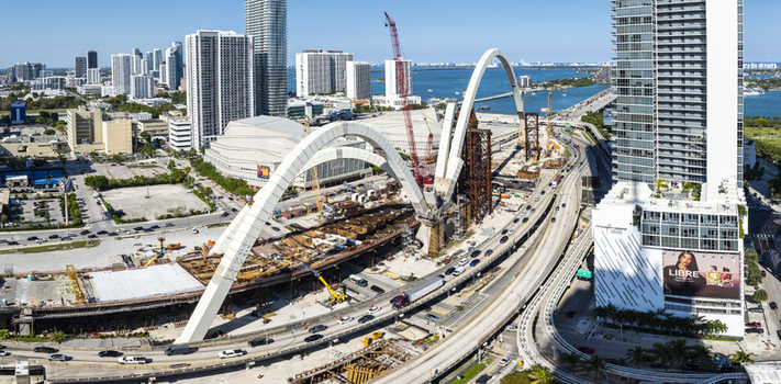 Aerial view of the Signature Bridge under construction a symphony of steel and concrete against the backdrop of Biscayne Bay Miami Florida USA. Aerial view of the Signature Bridge under construction a symphony of steel and concrete against the backdrop of Biscayne Bay Miami Florida USA.