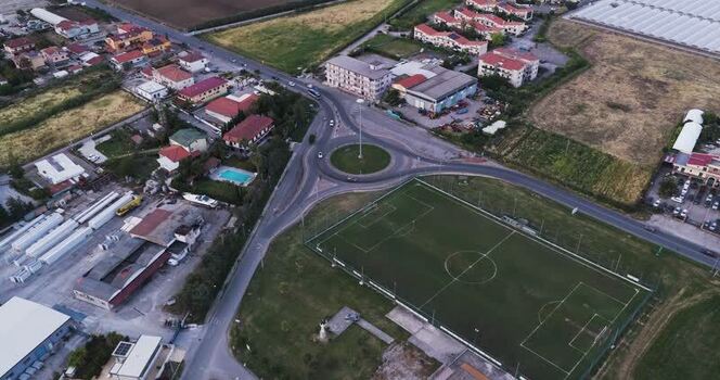 Aerial view of a football pitch and roundabout in Paestum Italy.