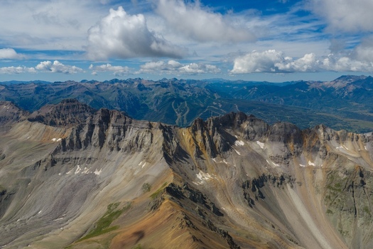 Aerial view of Telluride Ski Resort from Mount Sneffels and the rugged San Juan Mountains in the Rocky Mountains featuring rocky ridges steep slopes and patches of snow Ouray County Colorado USA Aerial view of Telluride Ski Resort from Mount Sneffels and the rugged San Juan Mountains in the Rocky Mountains featuring rocky ridges steep slopes and patches of snow Ouray County Colorado USA