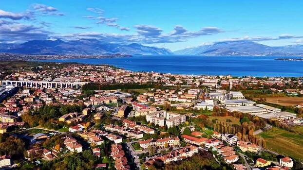 Aerial view of a lakeside town with mountains in the background Italy.