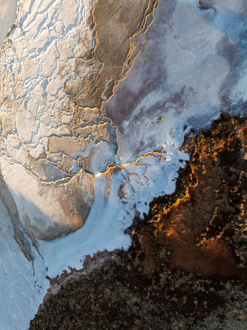 Aerial view of Reykjanes volcanic landscape with rugged lava fields geothermal textures and snow covered terrain under golden hour light in Grindavikurbaer Iceland. Aerial view of Reykjanes volcanic landscape with rugged lava fields geothermal textures and snow covered terrain under golden hour light in Grindavikurbaer Iceland.