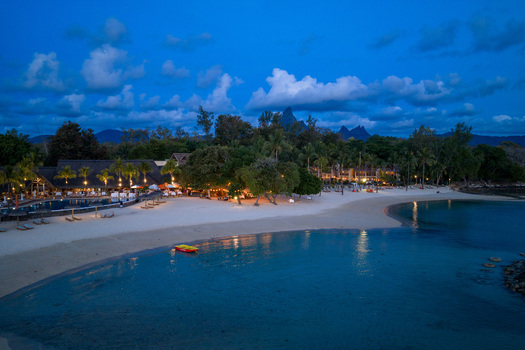 Aerial view of a luxury beach resort with illuminated buildings palm trees and white sand beach at twilight in Mauritius Moka District Mauritius. Aerial view of a luxury beach resort with illuminated buildings palm trees and white sand beach at twilight in Mauritius Moka District Mauritius.