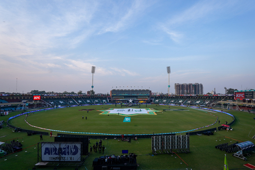 Lahore Pakistan 17 February 2024 View of Gaddafi Stadium with its expansive cricket pitch stadium seating and floodlight towers under a clear blue sky.