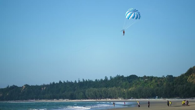View of a person parasailing over the beach Bangladesh. View of a person parasailing over the beach Bangladesh.
