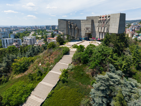 Aerial view of the Monument of the Bulgarian Soviet Friendship featuring a long concrete staircase leading up to the brutalist structure surrounded by lush greenery in Varna Varna Bulgaria.