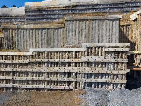 Aerial view of a large scale construction site featuring a reinforced concrete retaining wall with vertical structural piles and exposed soil in Istanbul Istanbul Turkiye. Aerial view of a large scale construction site featuring a reinforced concrete retaining wall with vertical structural piles and exposed soil in Istanbul Istanbul Turkiye.