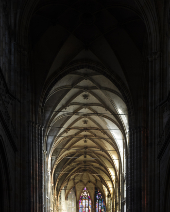 View of the intricate Gothic ribbed vaulting and stone arches inside St. Vitus Cathedral with stained glass windows in Prague Prague Czechia. View of the intricate Gothic ribbed vaulting and stone arches inside St. Vitus Cathedral with stained glass windows in Prague Prague Czechia.