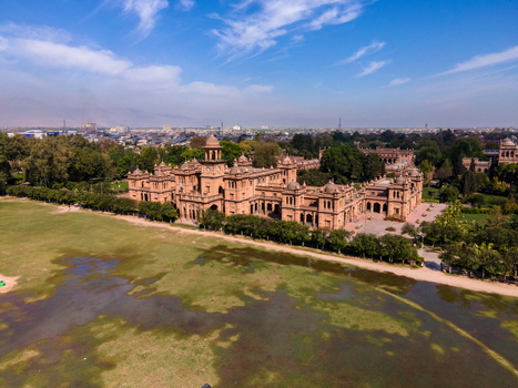 Aerial view of the historic Islamia College University Peshawar featuring iconic red brick architecture sprawling green lawns and surrounding trees in Peshawar Khyber Pakhtunkhwa Pakistan. Aerial view of the historic Islamia College University Peshawar featuring iconic red brick architecture sprawling green lawns and surrounding trees in Peshawar Khyber Pakhtunkhwa Pakistan.