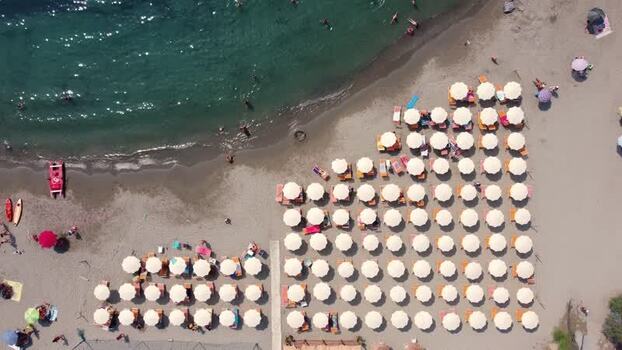 Aerial view of white beach umbrellas and people on the sandy shore Italy. Aerial view of white beach umbrellas and people on the sandy shore Italy.