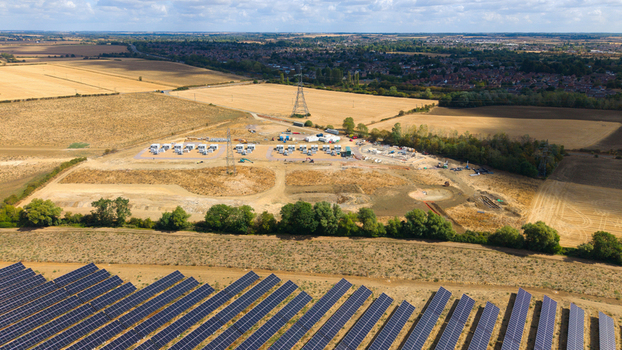 Aerial view of Eaton Socon Substation solar farm and battery energy storage systems surrounded by agricultural fields and rural landscape in St. Neots England United Kingdom. Aerial view of Eaton Socon Substation solar farm and battery energy storage systems surrounded by agricultural fields and rural landscape in St. Neots England United Kingdom.