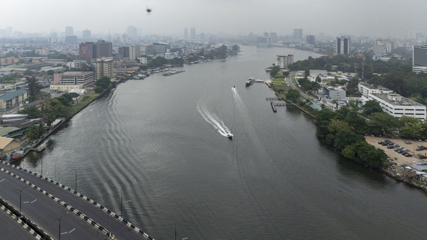 Aerial view of the Lagos Lagoon with boats traveling through the water surrounded by the urban skyline and buildings of Lagos Island in Lagos Lagos Nigeria. Aerial view of the Lagos Lagoon with boats traveling through the water surrounded by the urban skyline and buildings of Lagos Island in Lagos Lagos Nigeria.
