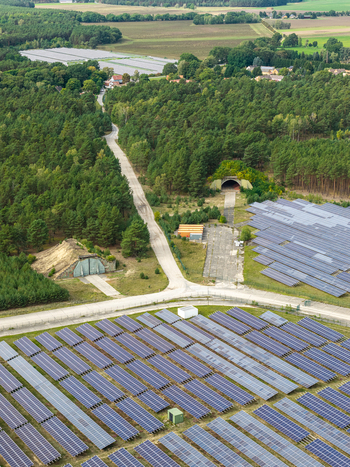 Aerial view of the former Preschen military airfield now a solar farm featuring historic hangars taxiways and rows of solar panels in Neisse Malxetal Brandenburg Germany. Aerial view of the former Preschen military airfield now a solar farm featuring historic hangars taxiways and rows of solar panels in Neisse Malxetal Brandenburg Germany.