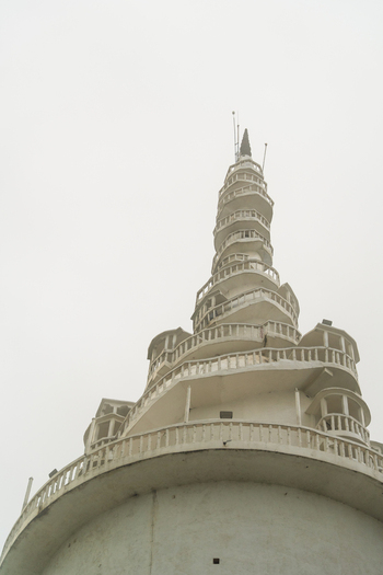 View of the white spiral Ambuluwawa Tower rising into a foggy sky Gampola Central Province Sri Lanka. View of the white spiral Ambuluwawa Tower rising into a foggy sky Gampola Central Province Sri Lanka.