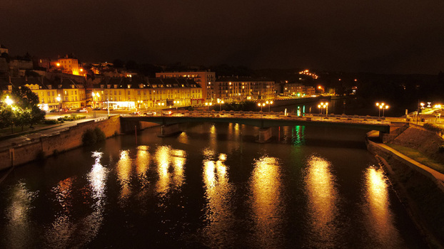 Aerial view of the illuminated bridge over the Oise river with historic buildings and street lights reflecting on the water at night in Pontoise Ile de France France. Aerial view of the illuminated bridge over the Oise river with historic buildings and street lights reflecting on the water at night in Pontoise Ile de France France.