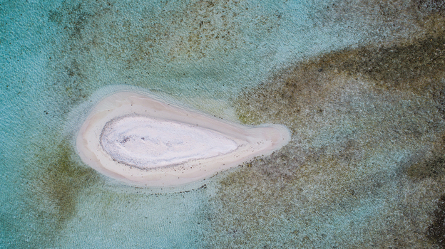 Aerial view of a small white sandy cay surrounded by turquoise shallow waters and coral reefs in the Los Roques archipelago Los Roques Dependencias Federale Venezuela. Aerial view of a small white sandy cay surrounded by turquoise shallow waters and coral reefs in the Los Roques archipelago Los Roques Dependencias Federale Venezuela.