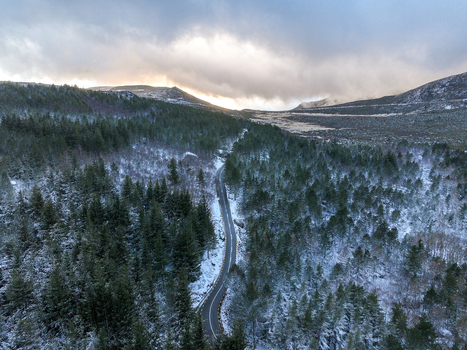 Aerial view of a winding road passing through a snow covered pine forest in the Serra da Estrela mountains Unhais da Serra Castelo Branco District Portugal. Aerial view of a winding road passing through a snow covered pine forest in the Serra da Estrela mountains Unhais da Serra Castelo Branco District Portugal.