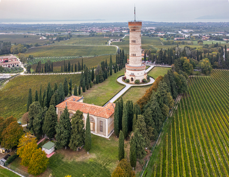 Aerial view of the Tower of San Martino della Battaglia surrounded by lush vineyards cypress trees and historic buildings in San Martino della Battaglia Lombardia Italy. Aerial view of the Tower of San Martino della Battaglia surrounded by lush vineyards cypress trees and historic buildings in San Martino della Battaglia Lombardia Italy.