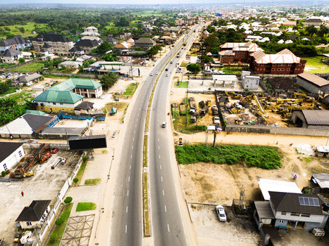 Aerial view of a long straight highway passing through residential neighborhoods and lush green vegetation in Port Harcourt Rivers Nigeria. Aerial view of a long straight highway passing through residential neighborhoods and lush green vegetation in Port Harcourt Rivers Nigeria.