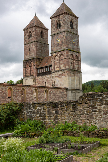 View of Hennebergisches Museum Kloster Vessra with its twin stone towers ancient walls and a lush herb garden under a cloudy sky Kloster Vessra Thuringen Germany. View of Hennebergisches Museum Kloster Vessra with its twin stone towers ancient walls and a lush herb garden under a cloudy sky Kloster Vessra Thuringen Germany.