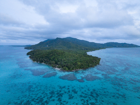 Aerial view of lush green island surrounded by turquoise waters a serene tropical paradise Karimunjawa Central Java Indonesia. Aerial view of lush green island surrounded by turquoise waters a serene tropical paradise Karimunjawa Central Java Indonesia.