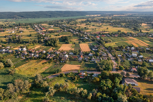 Aerial view of a patchwork of golden fields and verdant trees embracing quaint houses under the vast sky Chyhyryns kyi district Cherkasy Oblast Ukraine.