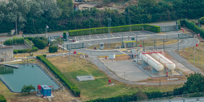 Aerial view of an industrial gas facility with storage tanks technical infrastructure secured access roads and a water pond in Loriol sur Drome Auvergne Rhone Alpes France.